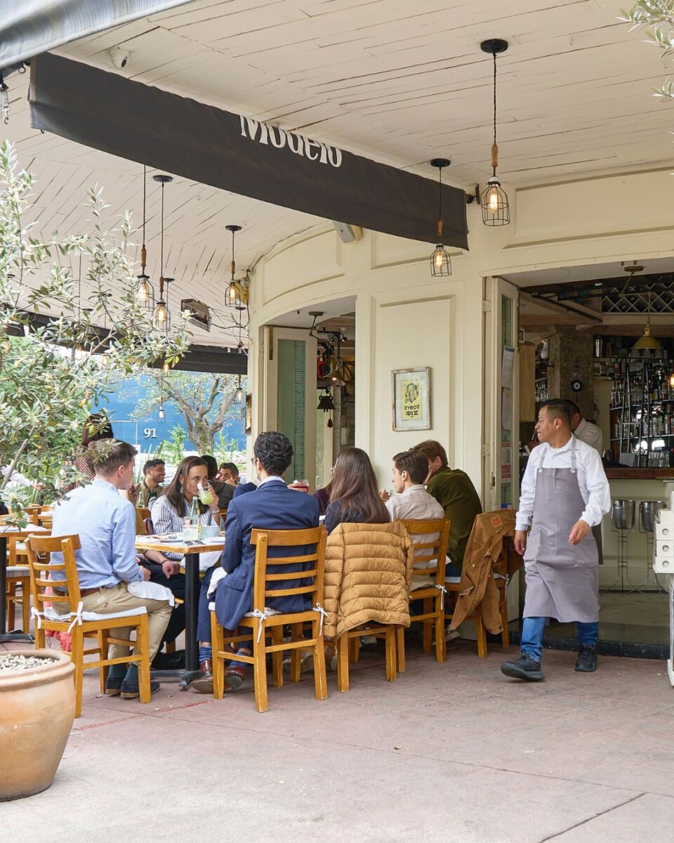 Terraza con mesas exteriores en el restaurante griego ouzeria