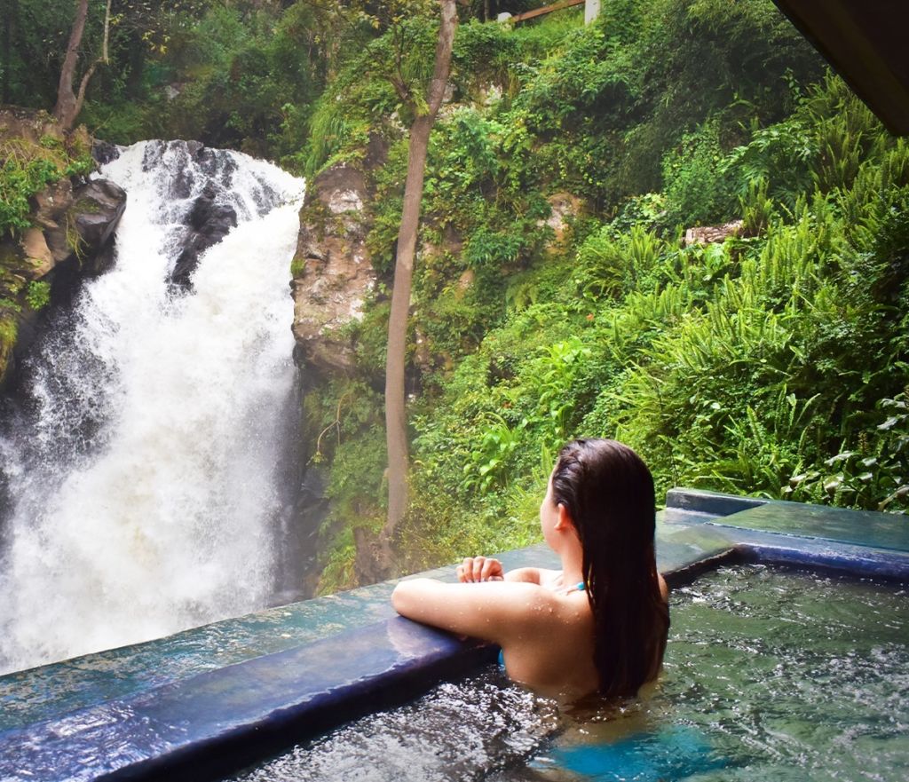 Mujer admirando la cascada del hotel Mision Grand Valle de Bravo