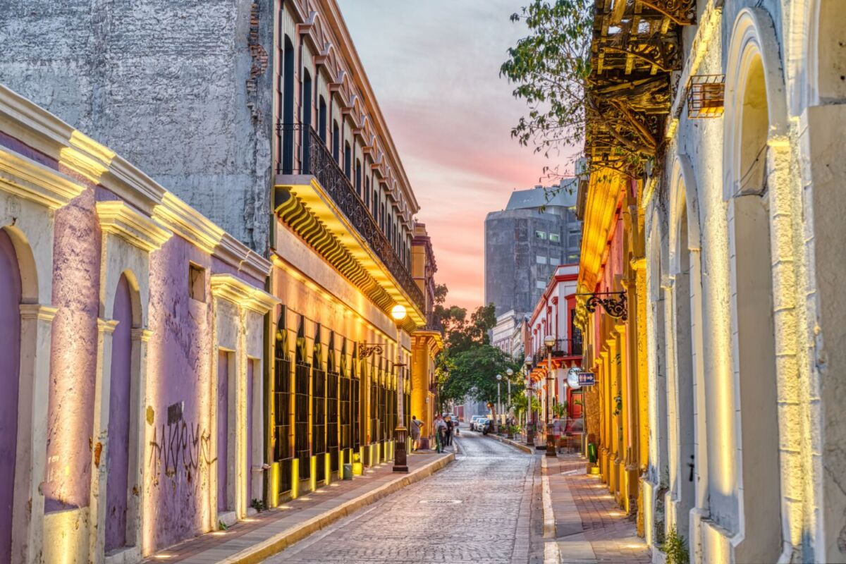 Calle del centro histórico de Mazatlán con edificios coloniales y luz de atardecer.