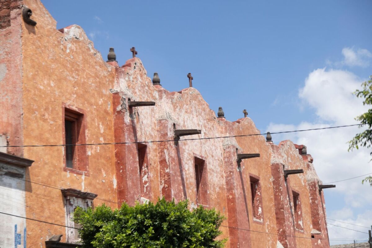 Fachada de edificio histórico con muros de color tierra en San Juan del Río, Querétaro.