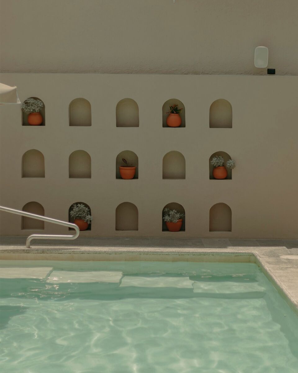 Alberca interior con muros de piedra y chimenea en Hacienda Santo Cristo, hotel boutique en México