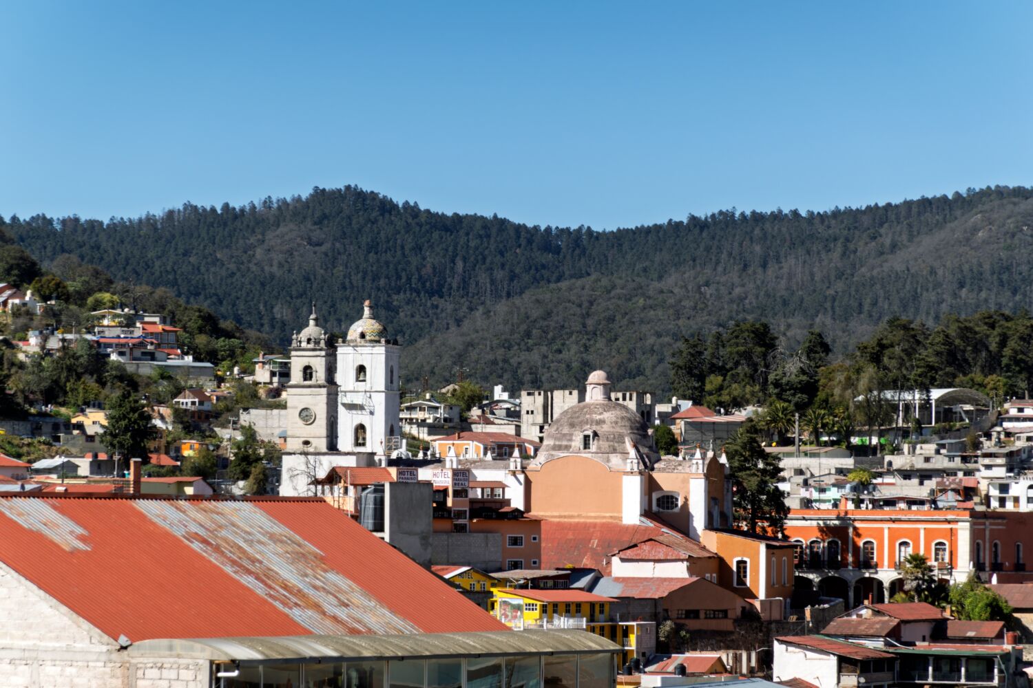 Torre blanca y cúpula de la iglesia de Real del Monte frente al bosque de pinos de la sierra hidalguense