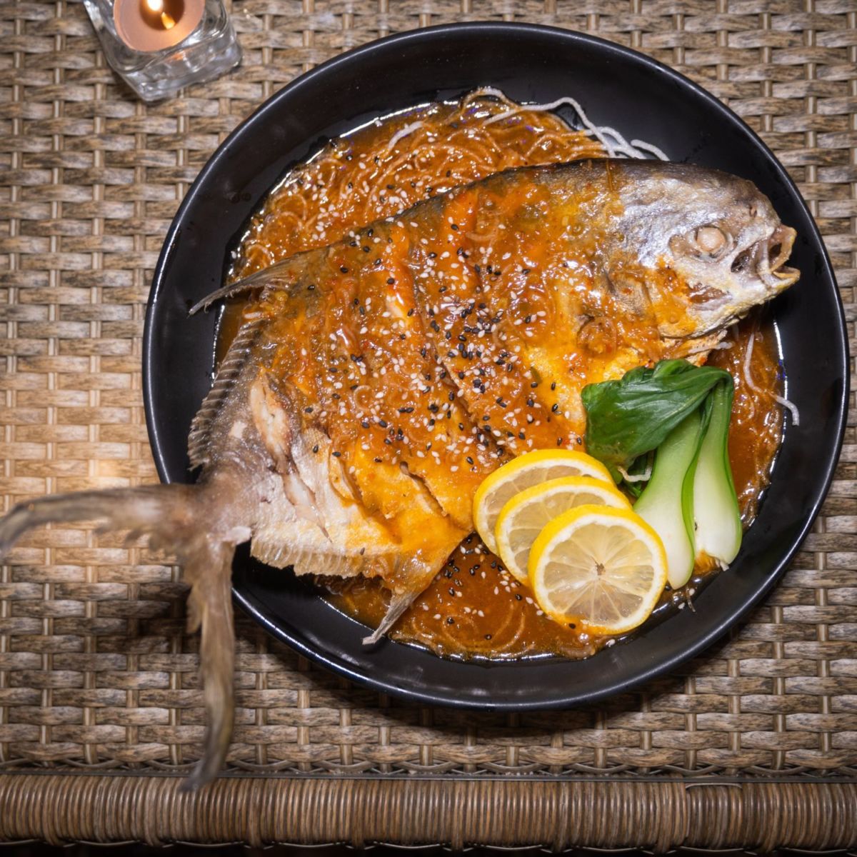 Pescado frito acompañado con fideos de soya, preparado en Ichi Restaurante.