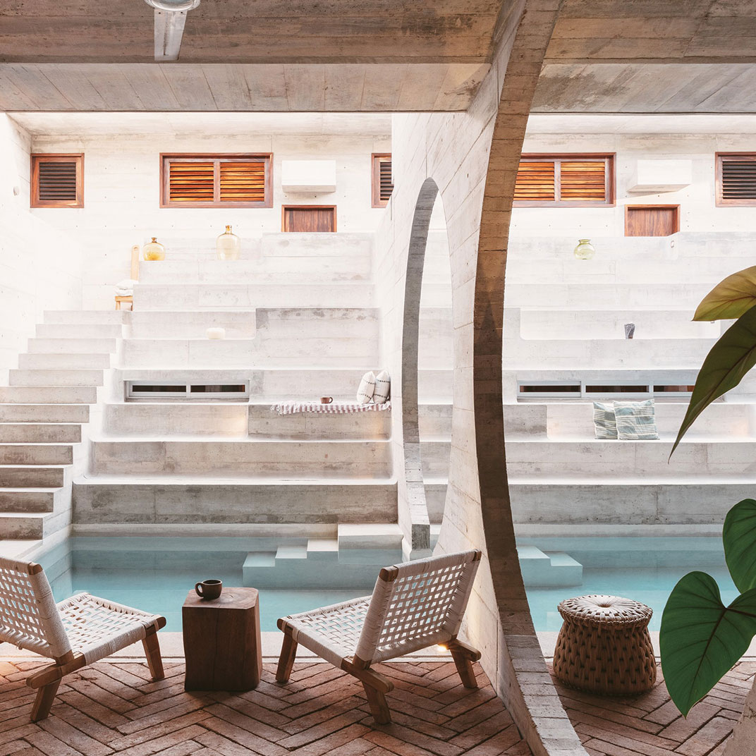 Las paredes de Casa TO están perforadas con grandes aberturas circulares para aprovechar en enfiamento natural