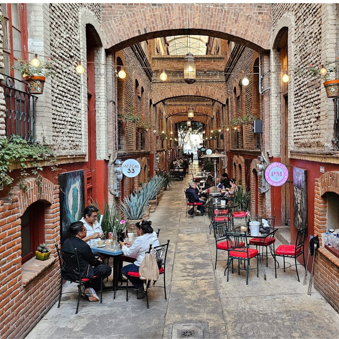 Pasillo interior de la Privada Roja en la colonia San Rafael con restaurantes, arquitectura de ladrillo y ambiente tranquilo en la CDMX.