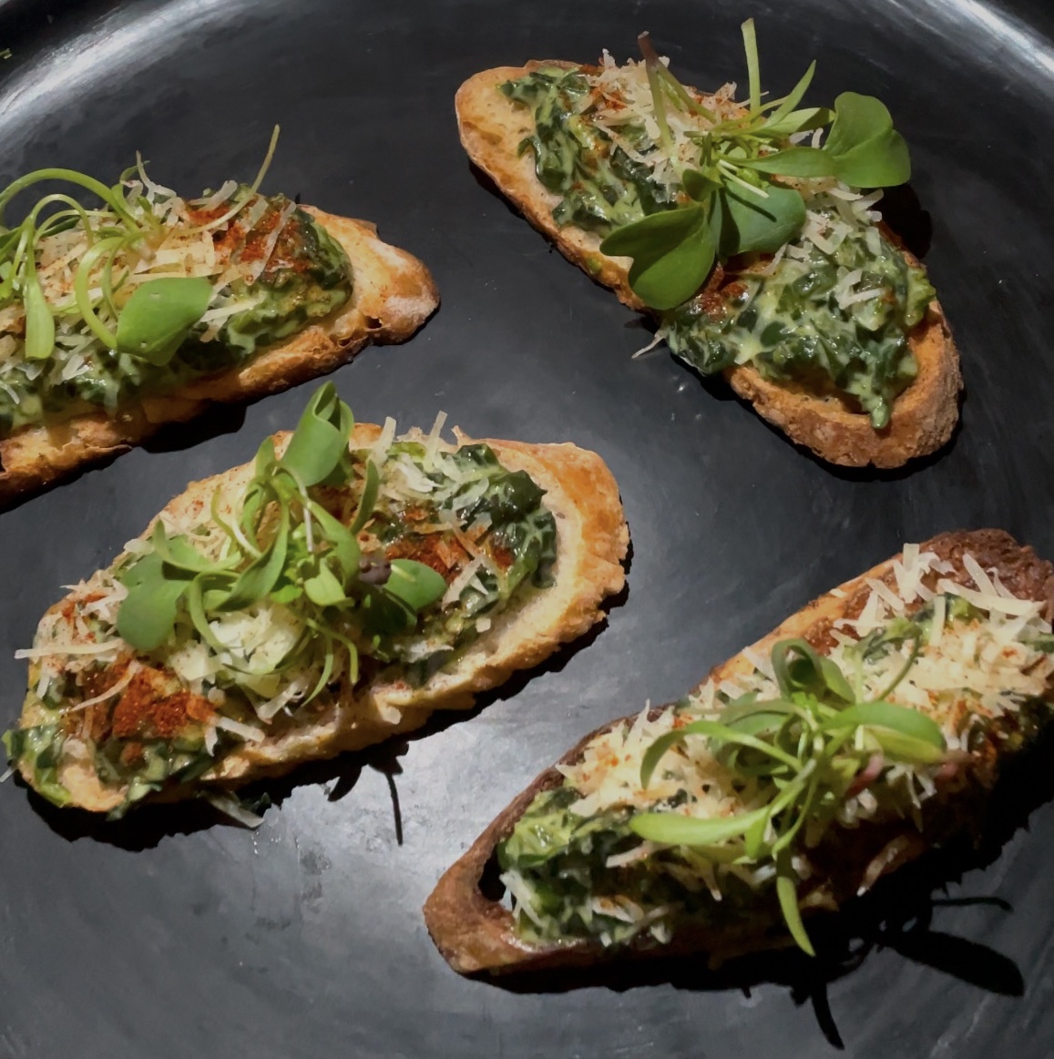 Dip de espinaca acompañado de panes y tostaditas