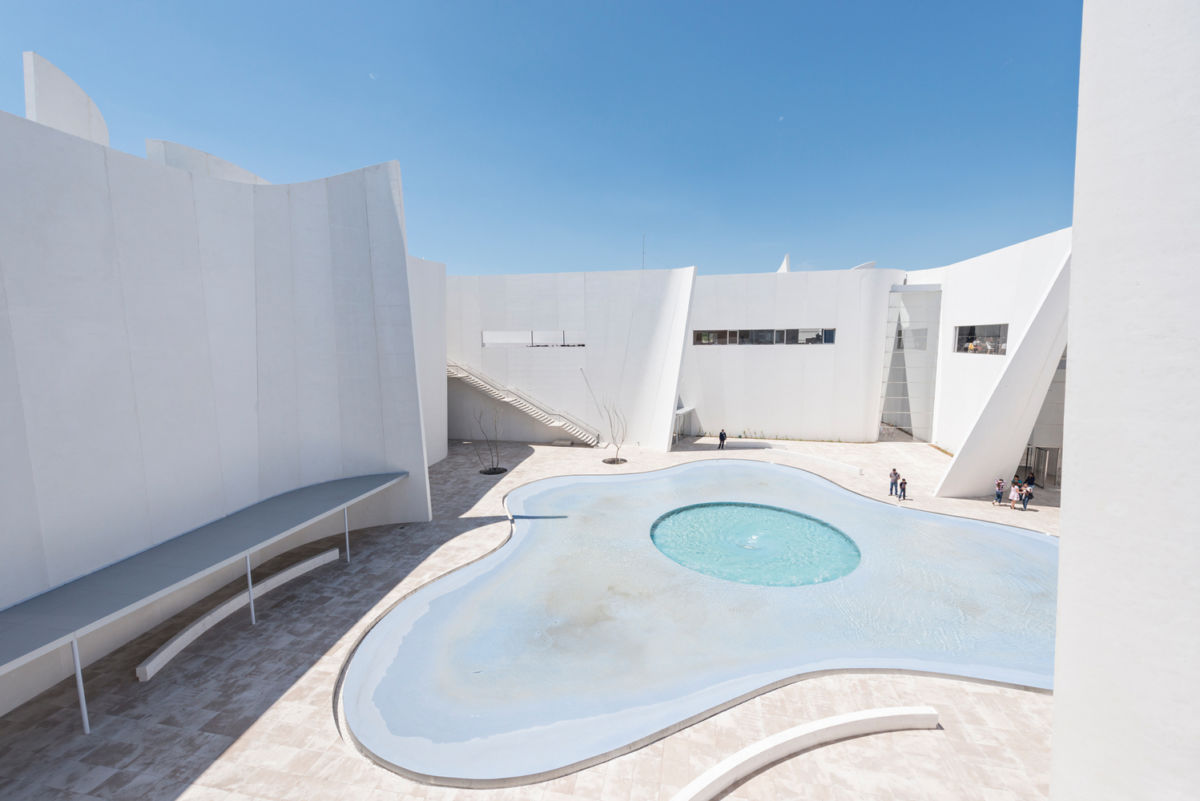 Hay un patio central con un espejo de agua y un remolino en el centro