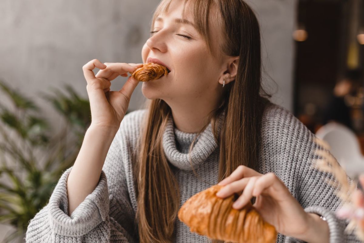 Mujer disfrutando de su pan dulce. 