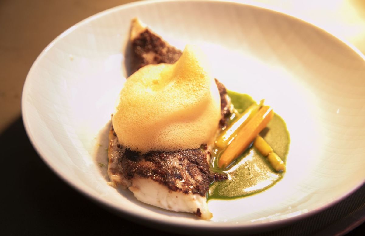 Lubina con aceitunas negras al pil pil, acompañada de vegetales y zanahoria. 