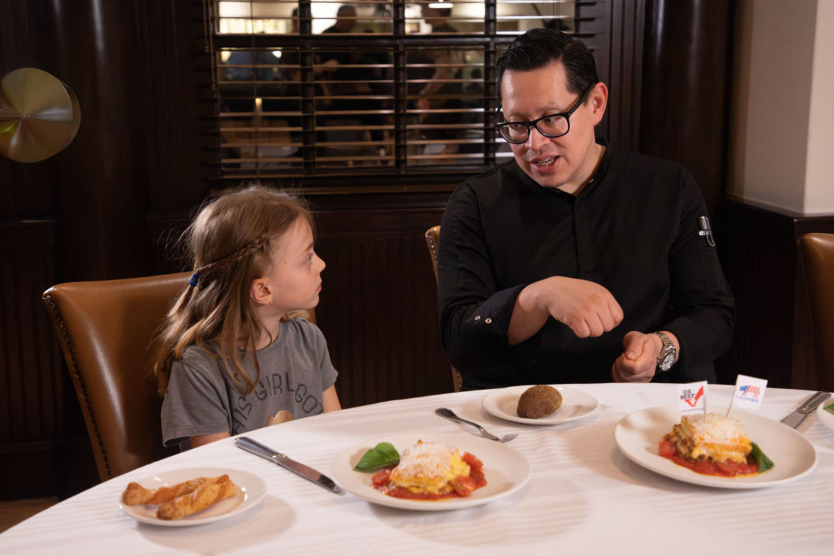 Niña hablando con chef en restaurante