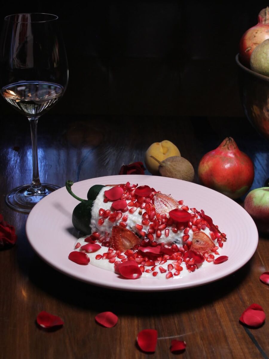 Chiles en nogada con fresas deshidratadas, granada y rosas