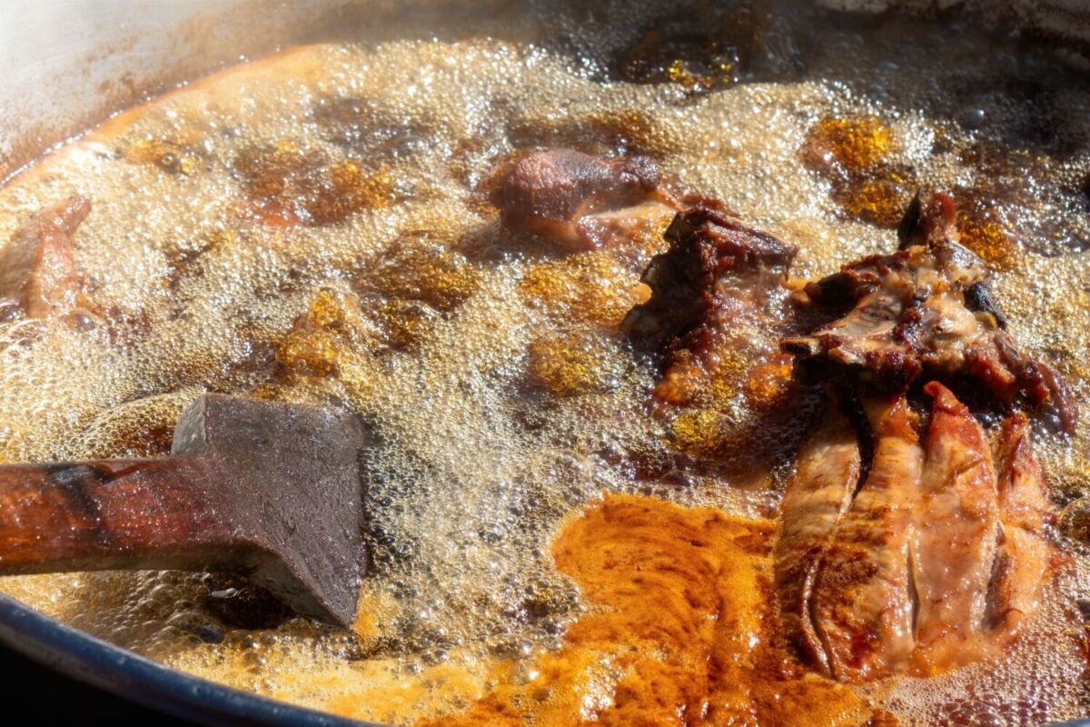  La carne de cerdo se cocina a fuego lento en ollas de cobre con manteca, agua, sal y ajo 