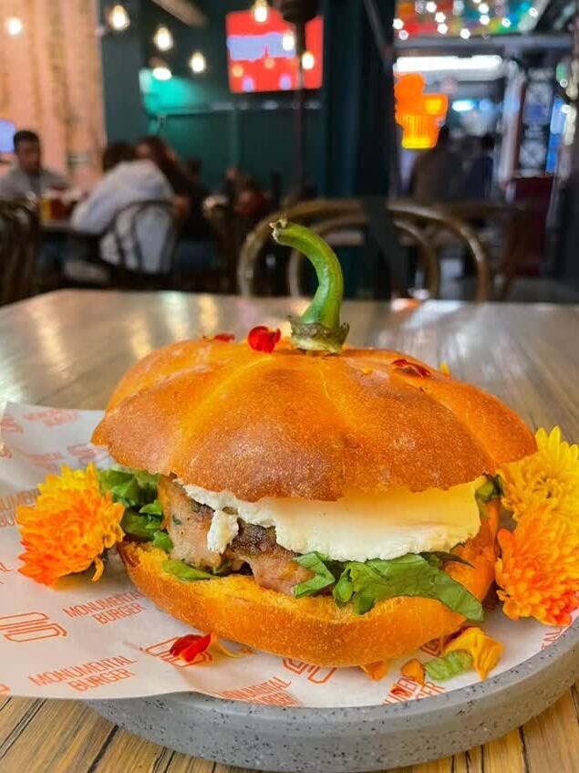  Mictlán Burger es una hamburguesa servida en un pan en forma de calabaza que lleva carne de res y cerdo