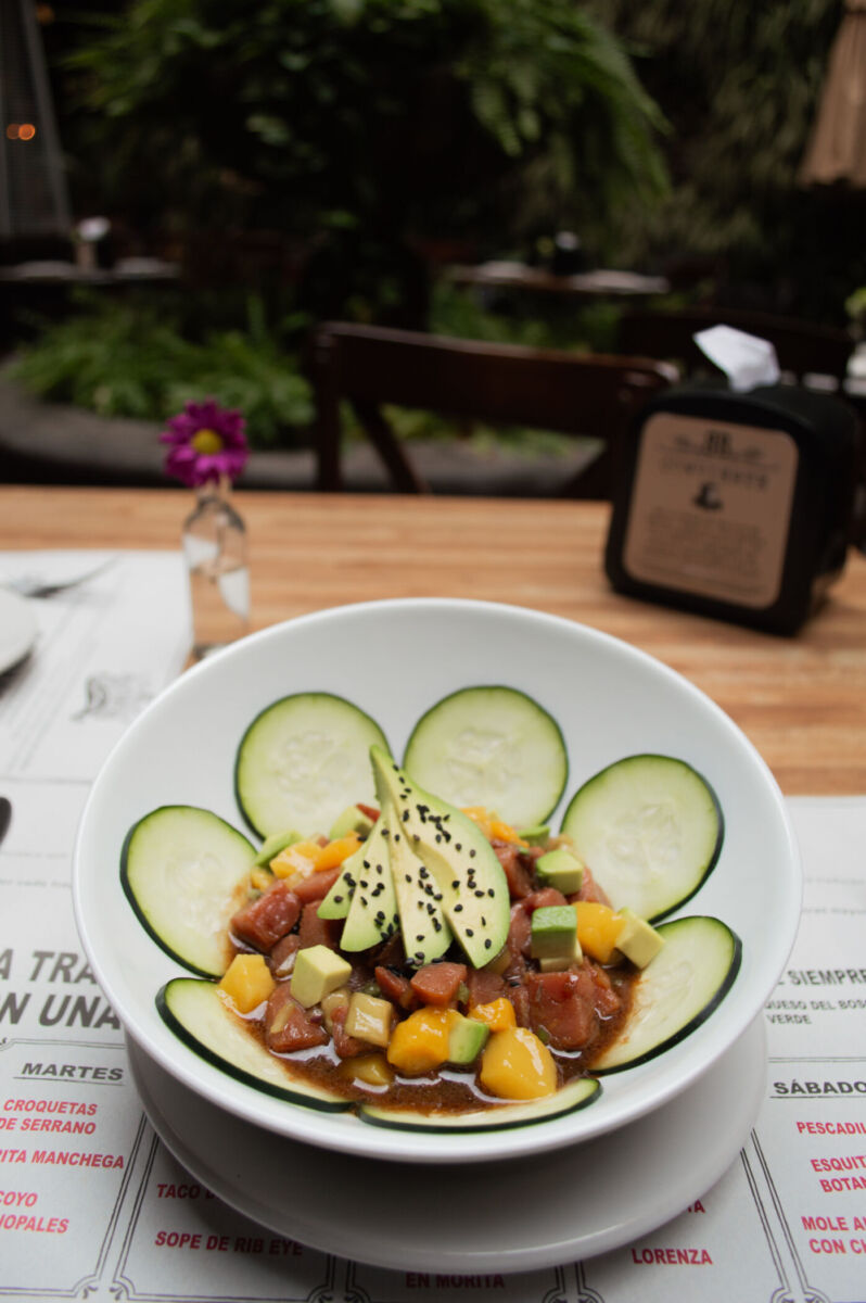 Ceviche de atún con mango y pepino, decorado con aguacate y ajonjolí negro