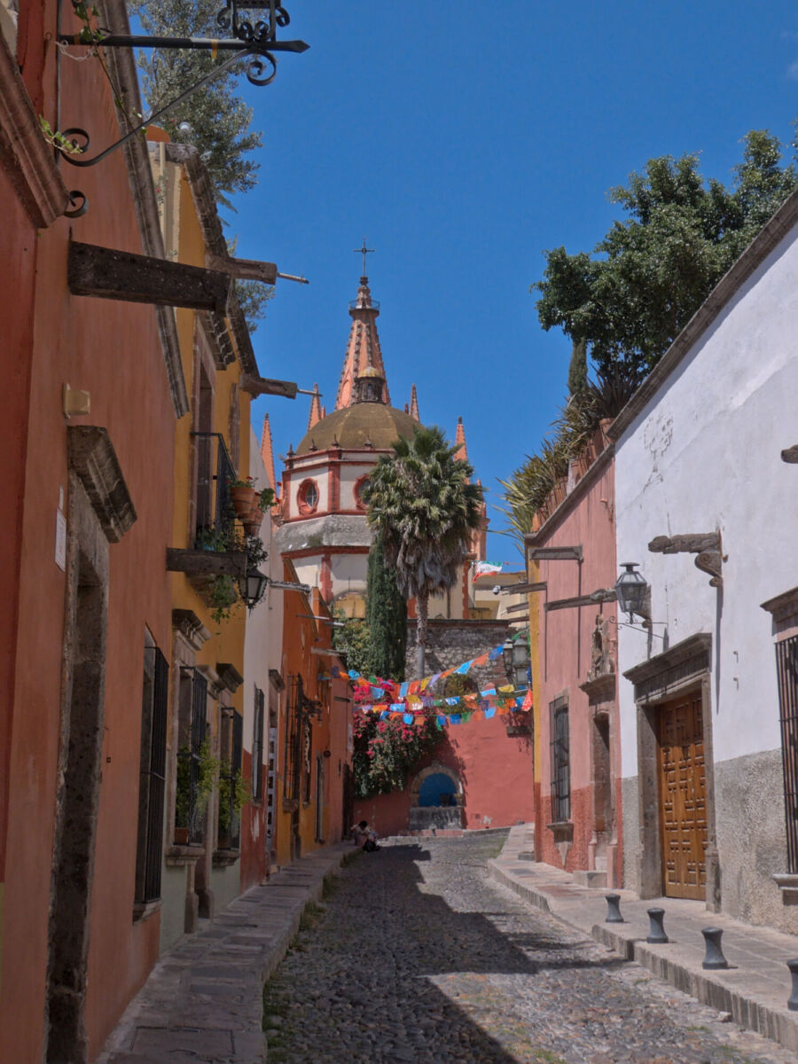 calle empedrada con vista a una antigua parroquia 