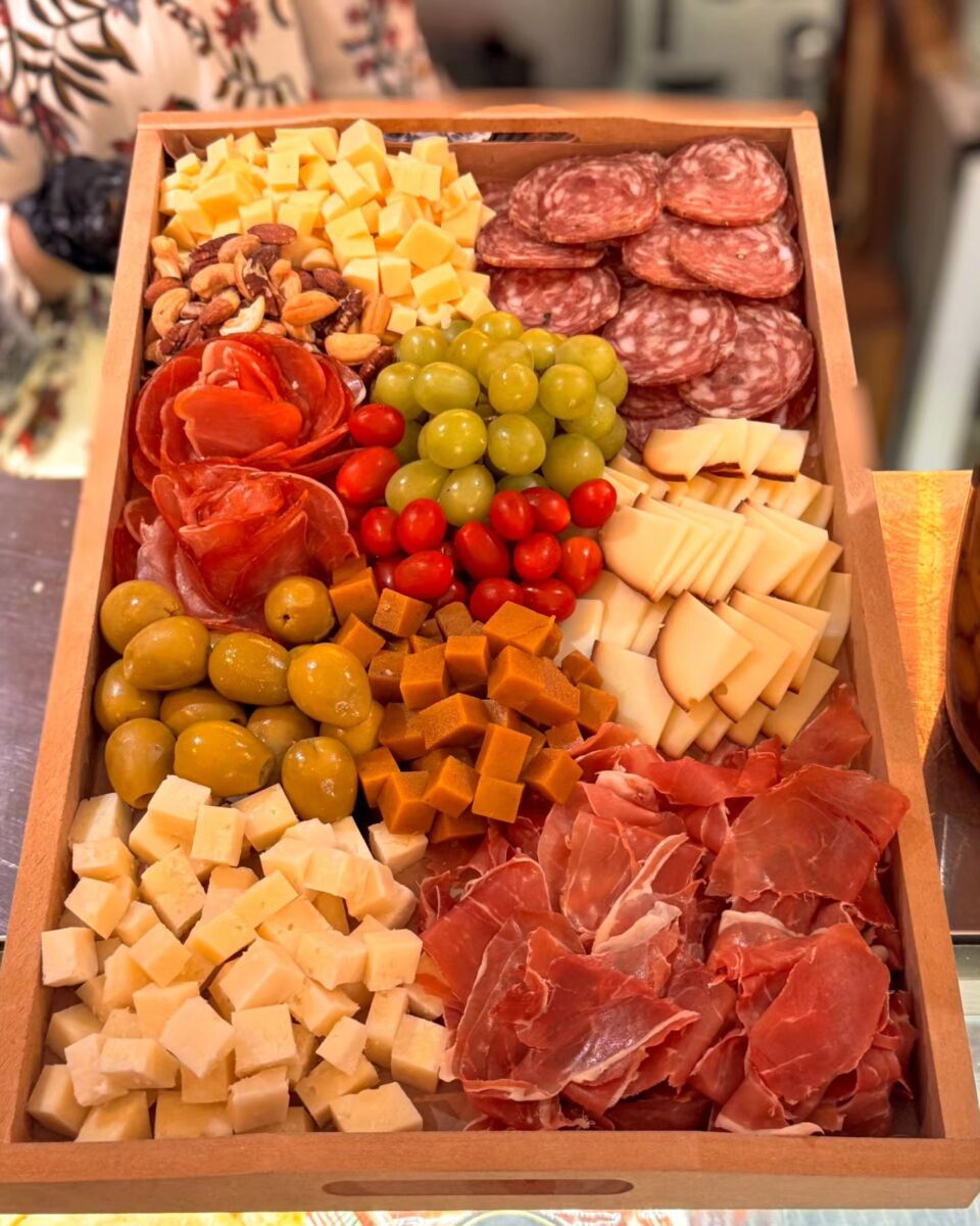 tabla de carnes frías, quesos, aceitunas y uvas