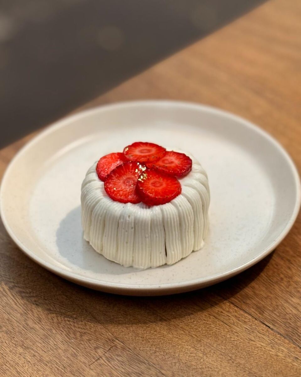 pastel cubierto con betún blanco y con rebanadas de fresa