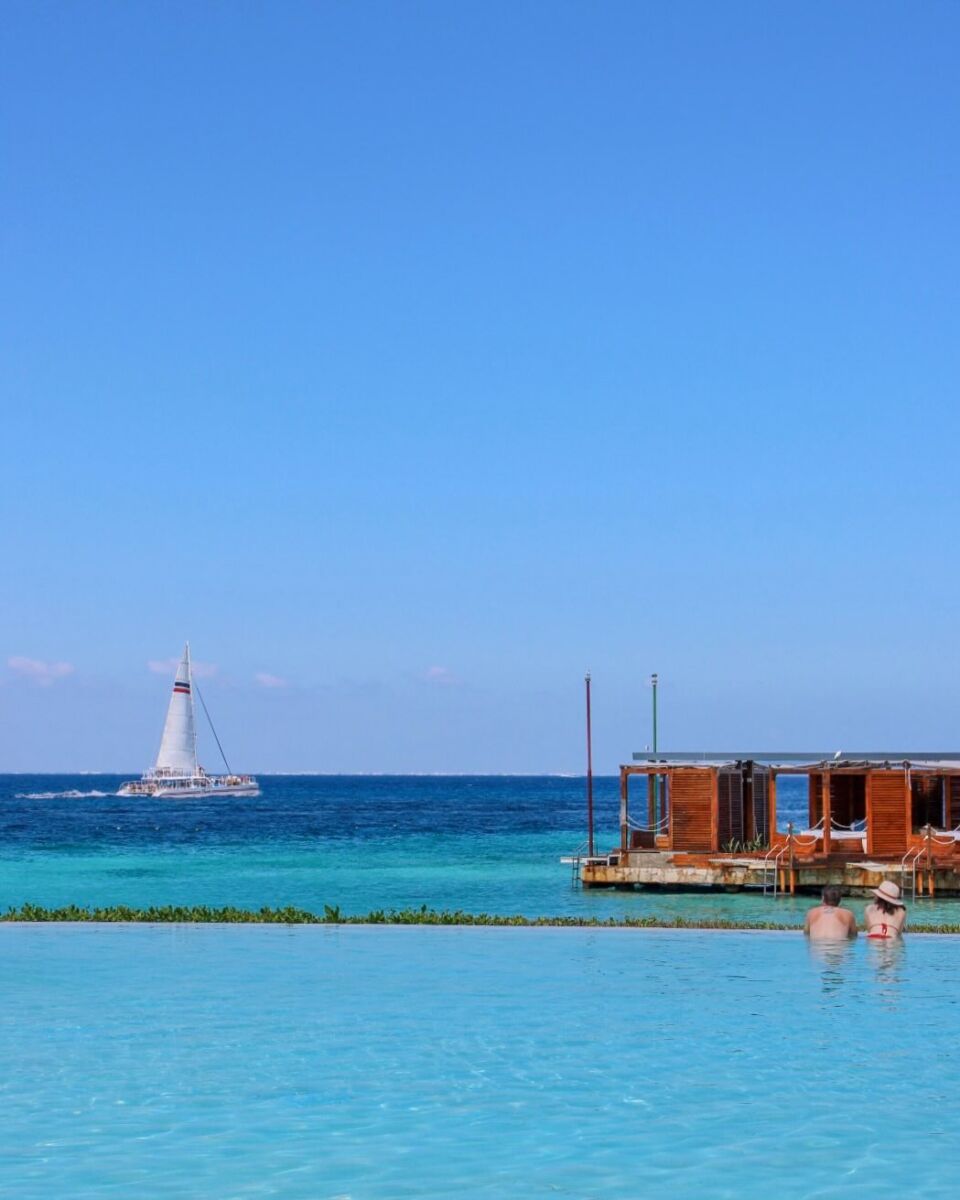 personas en la piscina contemplando el mar azul 
