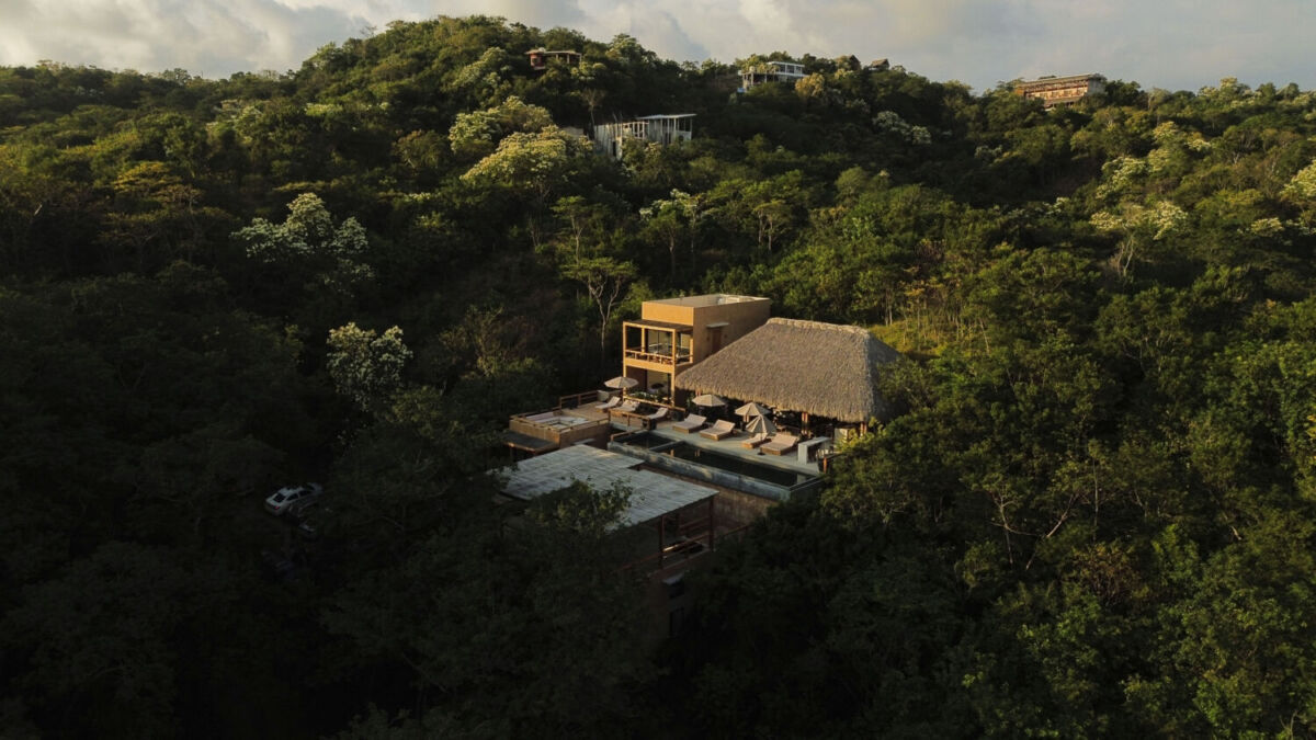 vista aérea de un hotel con alberca en medio de la selva