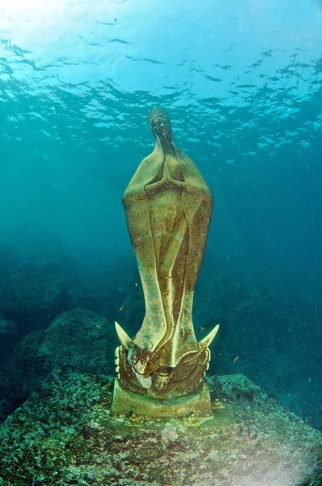 escultura dorada de una virgen sumergida bajo el agua