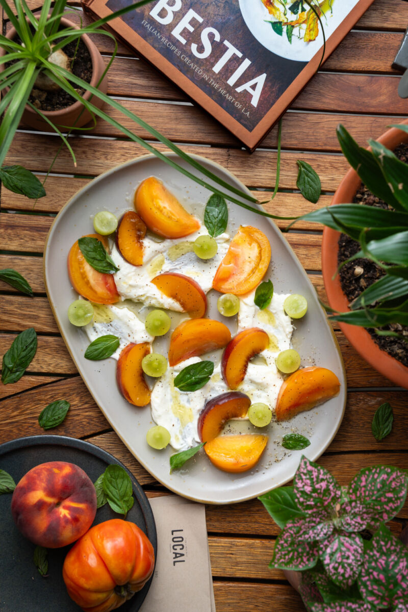 plato de jitomates rebanados y uvas con queso