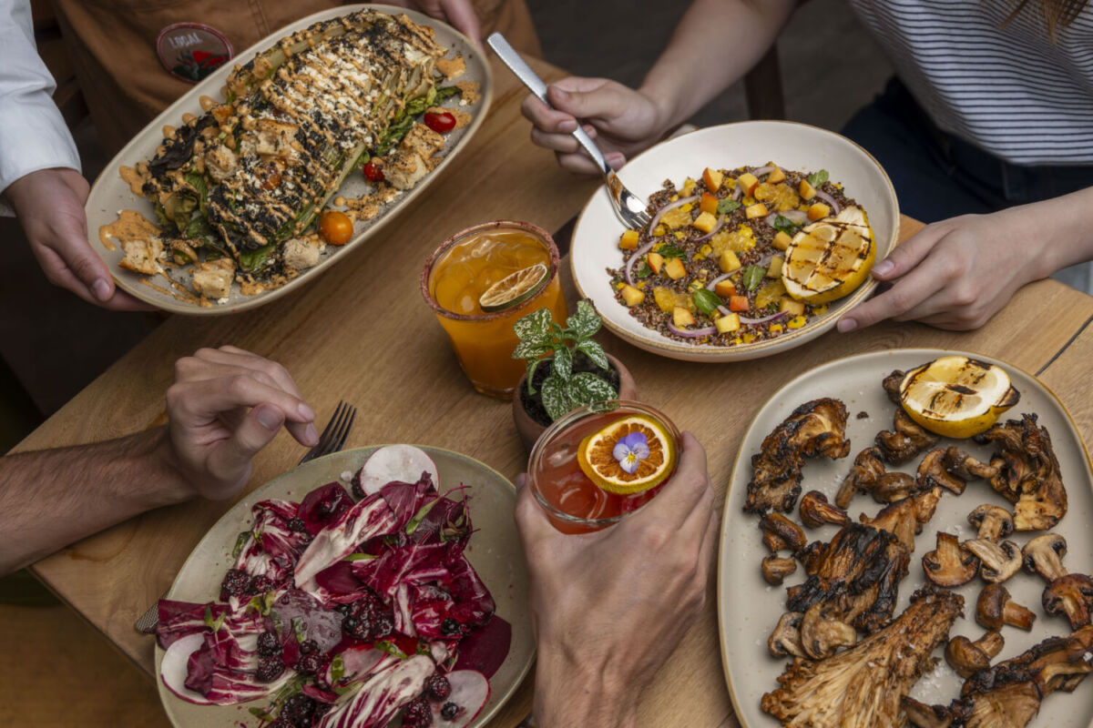 toma cerrada de gente compartiendo la mesa con platos grandes al centro
