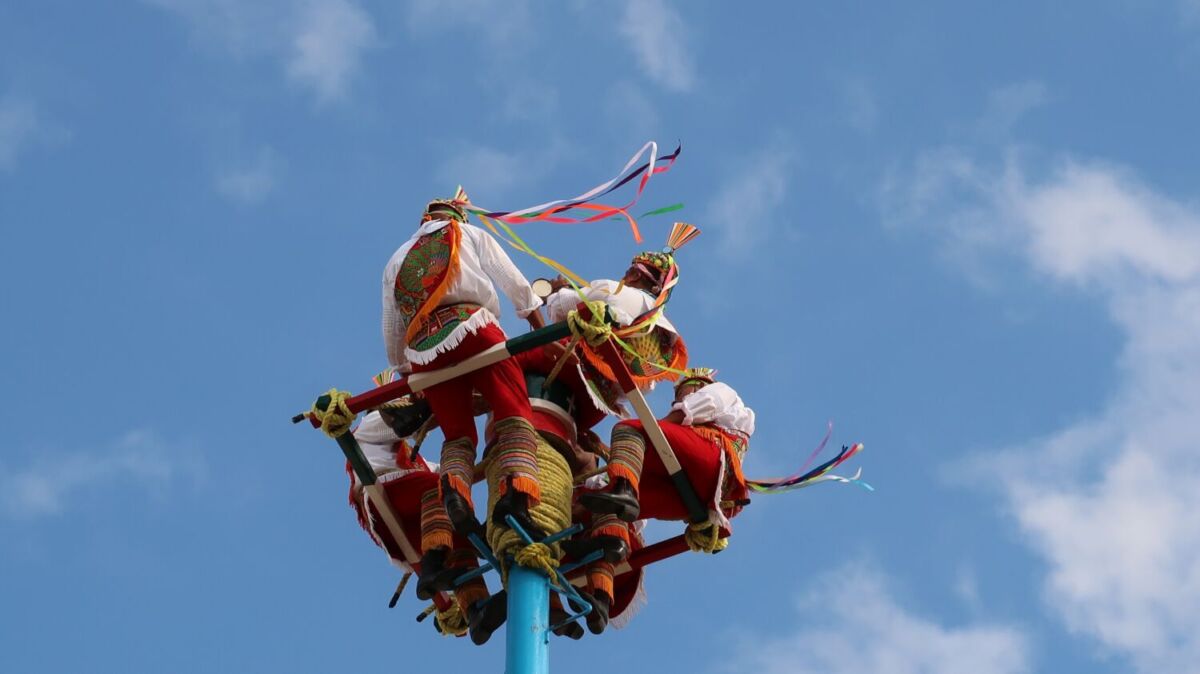 Grupo de hombres practicando una danza aérea 
