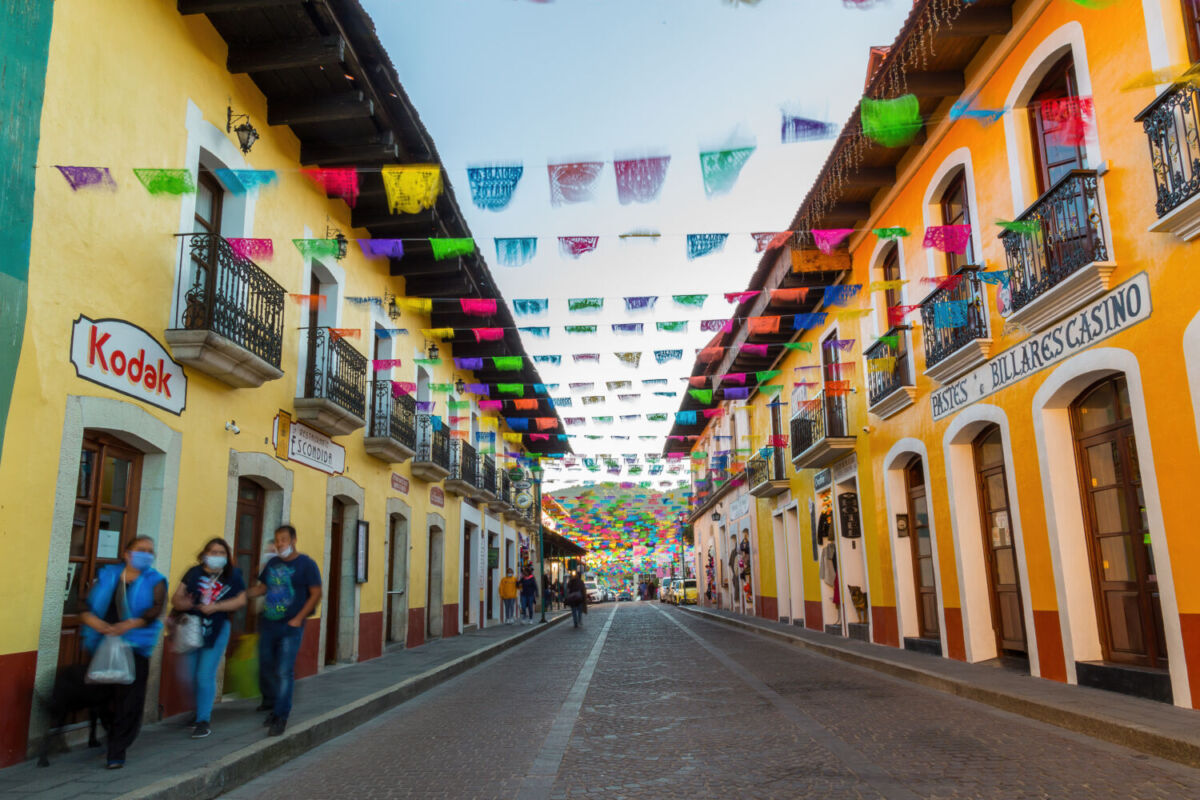 Calle empedrada en Real del Monte decorada con papel picado 