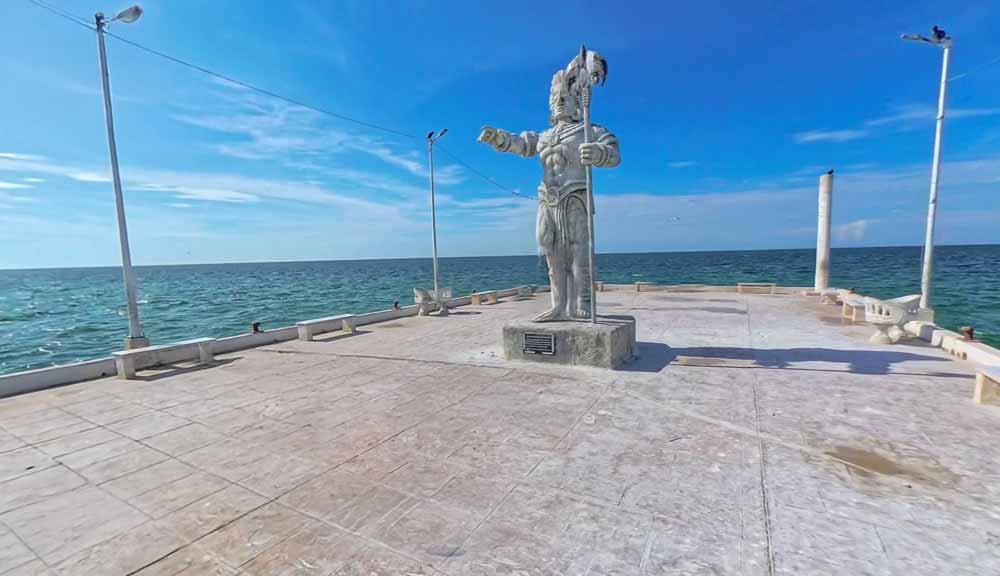muelle frente al mar con la escultura del dios maya chaac