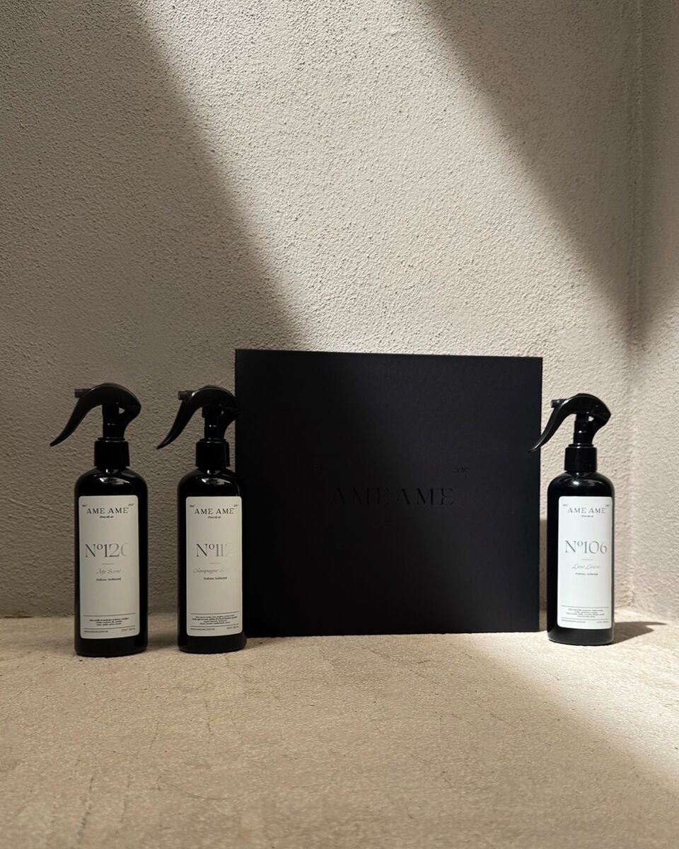 tres atomizadores negros con etiquetas blancas y una caja negra