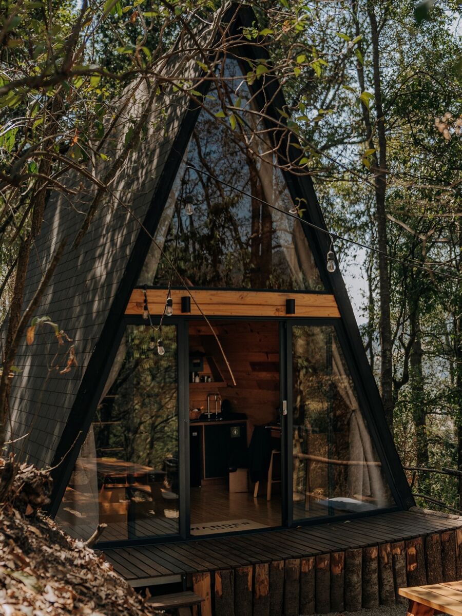 cabaña triangular en medio del bosque 