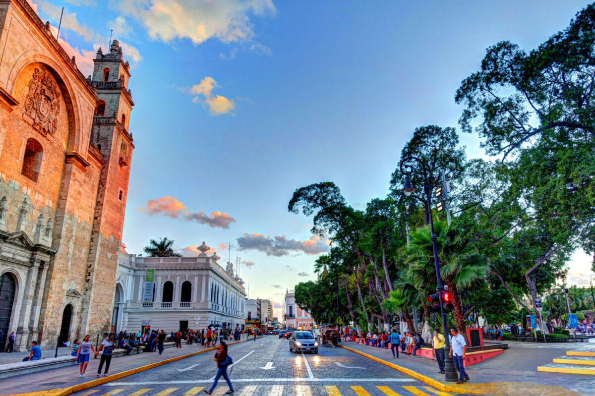 calle tranquila con pocos coches y gente caminando en mérida, Yucatán 