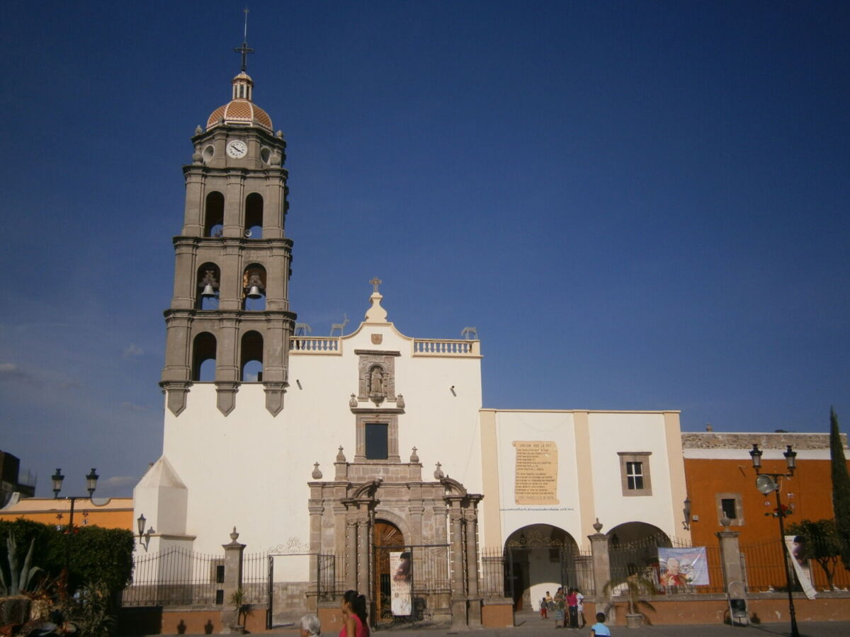 iglesia de fachada blanca con una torre de piedra