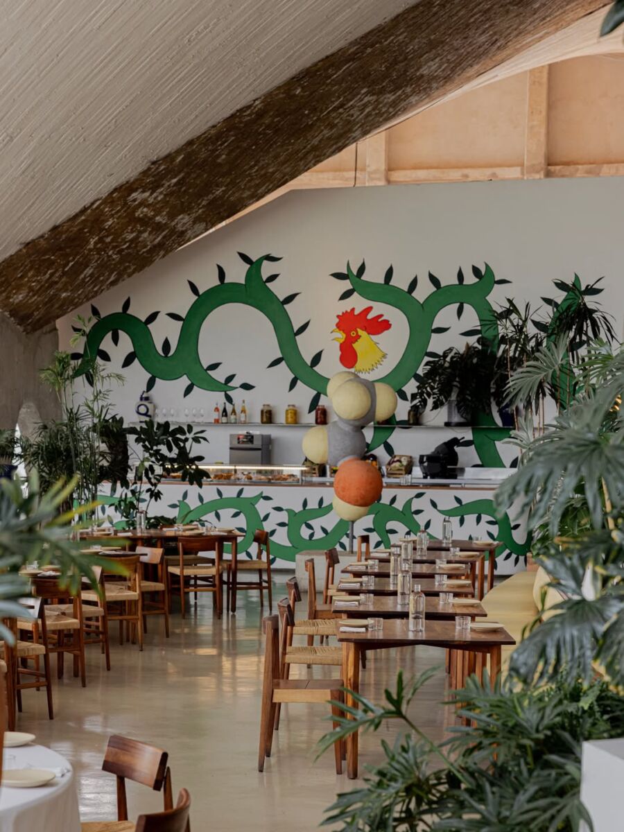 restaurante lago lgo con murales, plantas y mesas de madera