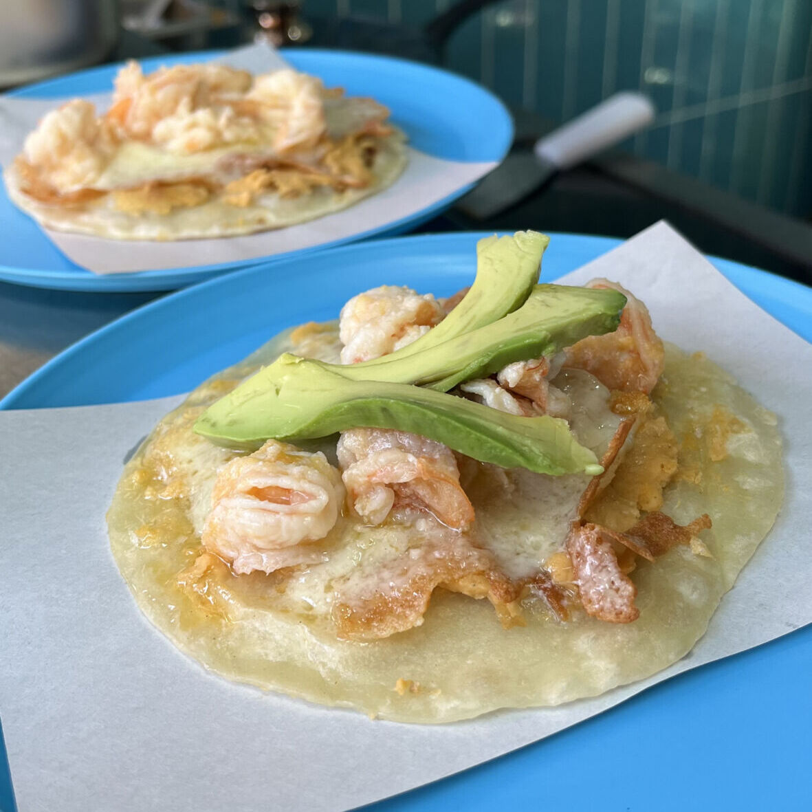 taco de camarón con tortilla de harina, costra de queso y aguacate