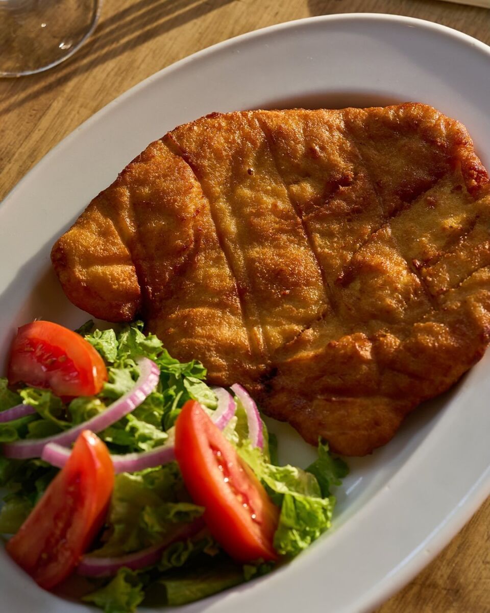 milanesa empalizada servida con ensalada 