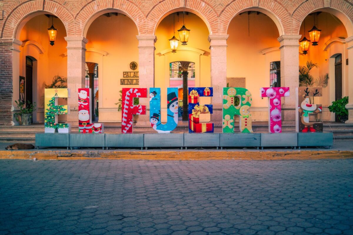 letras coloridas de "El Fuerte" frente a un edificio con arcos de medio punto de ladrillo