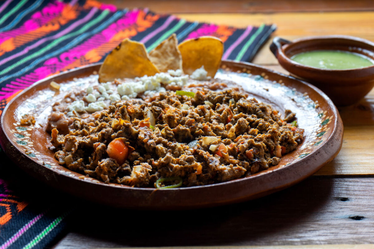machaca y frijoles con totopos servidos en un plato de barro 