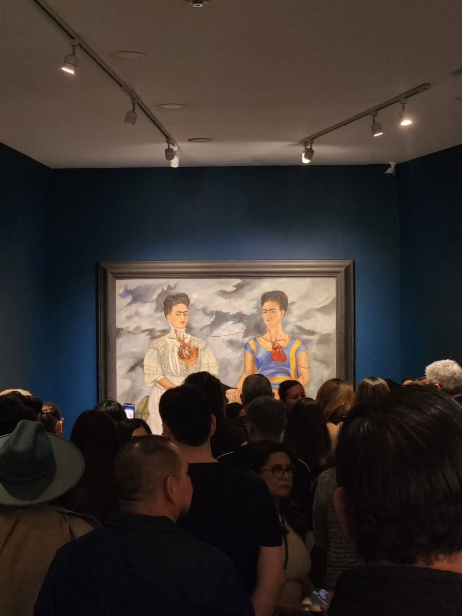 grupo de personas admirando un cuadro de Frida Kahlo 