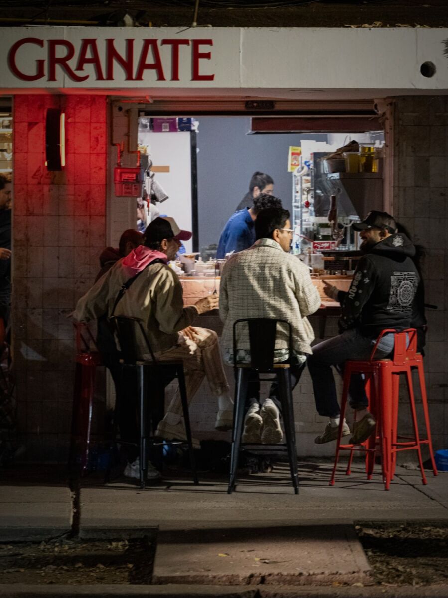 Grupo de amigos sentados en las mesas exteriores de un wine bar en la CDMX