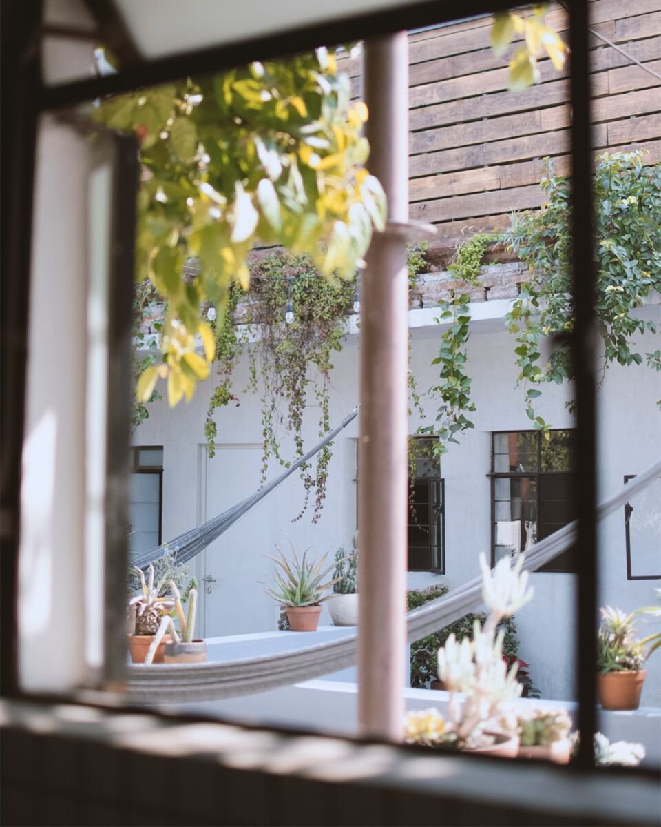 vista desde una ventaba hace una terraza con hamacas 