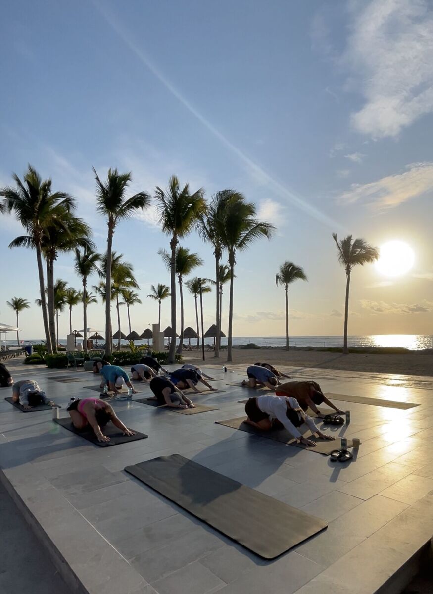 Clase de yoga al amanecer frente a la playa en Tulum 