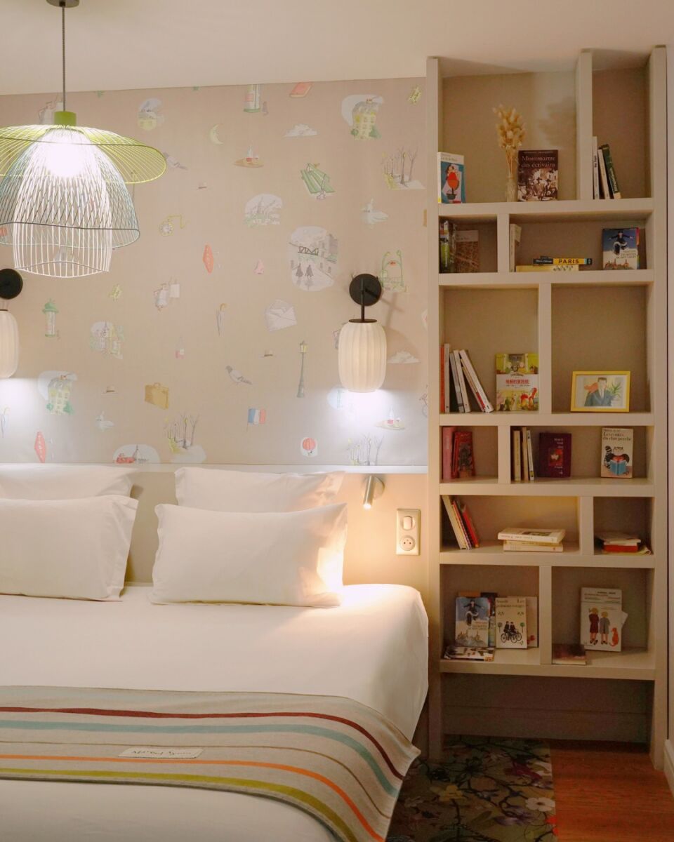 habitación con un una cama con sábanas blancas, un librero geometrico y una decoracion minimalista