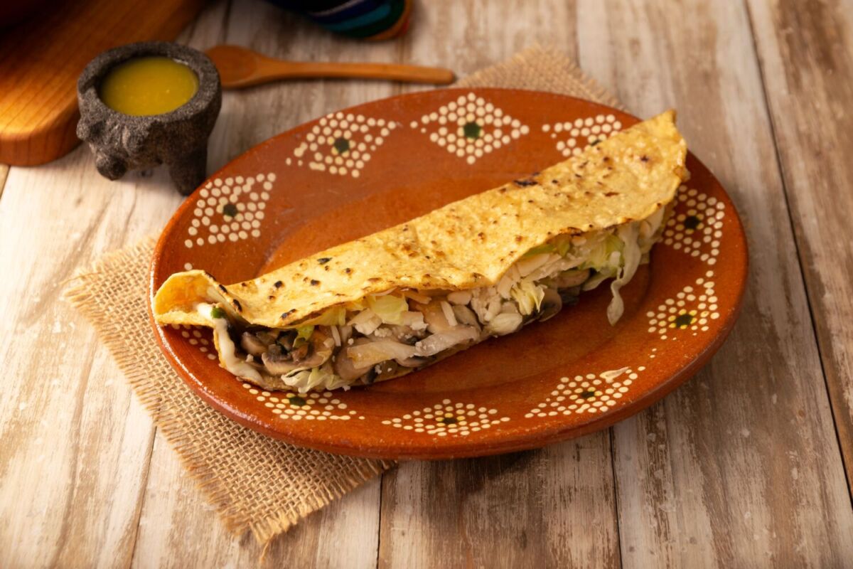 quesadilla de hongos servida en un plato de barro 