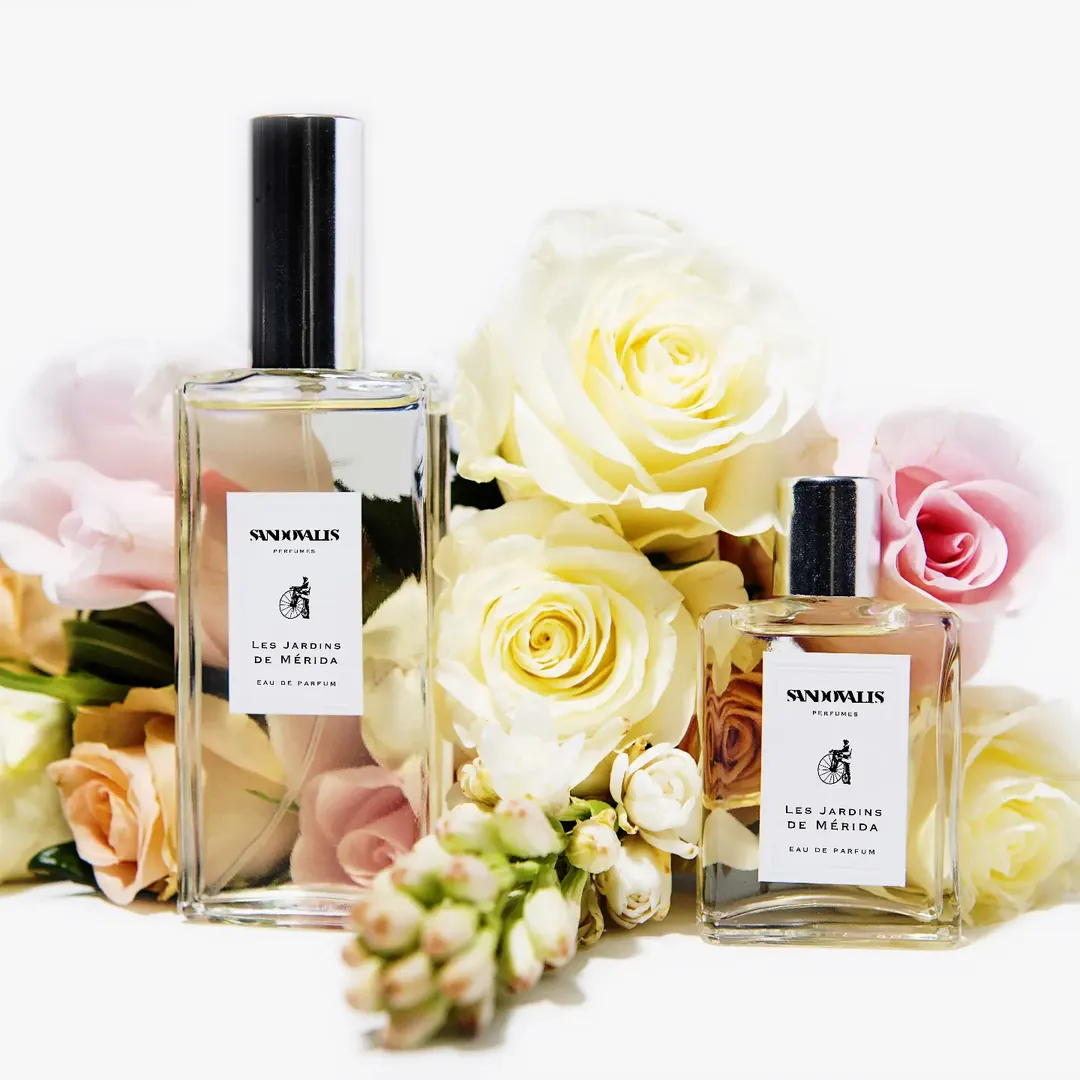 Botellas de perfumes flores de colores en fondo blanco