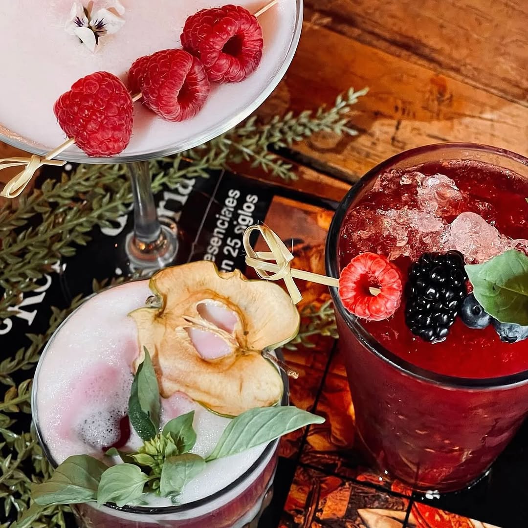 tres cocteles frutales sobre una mesa de bar