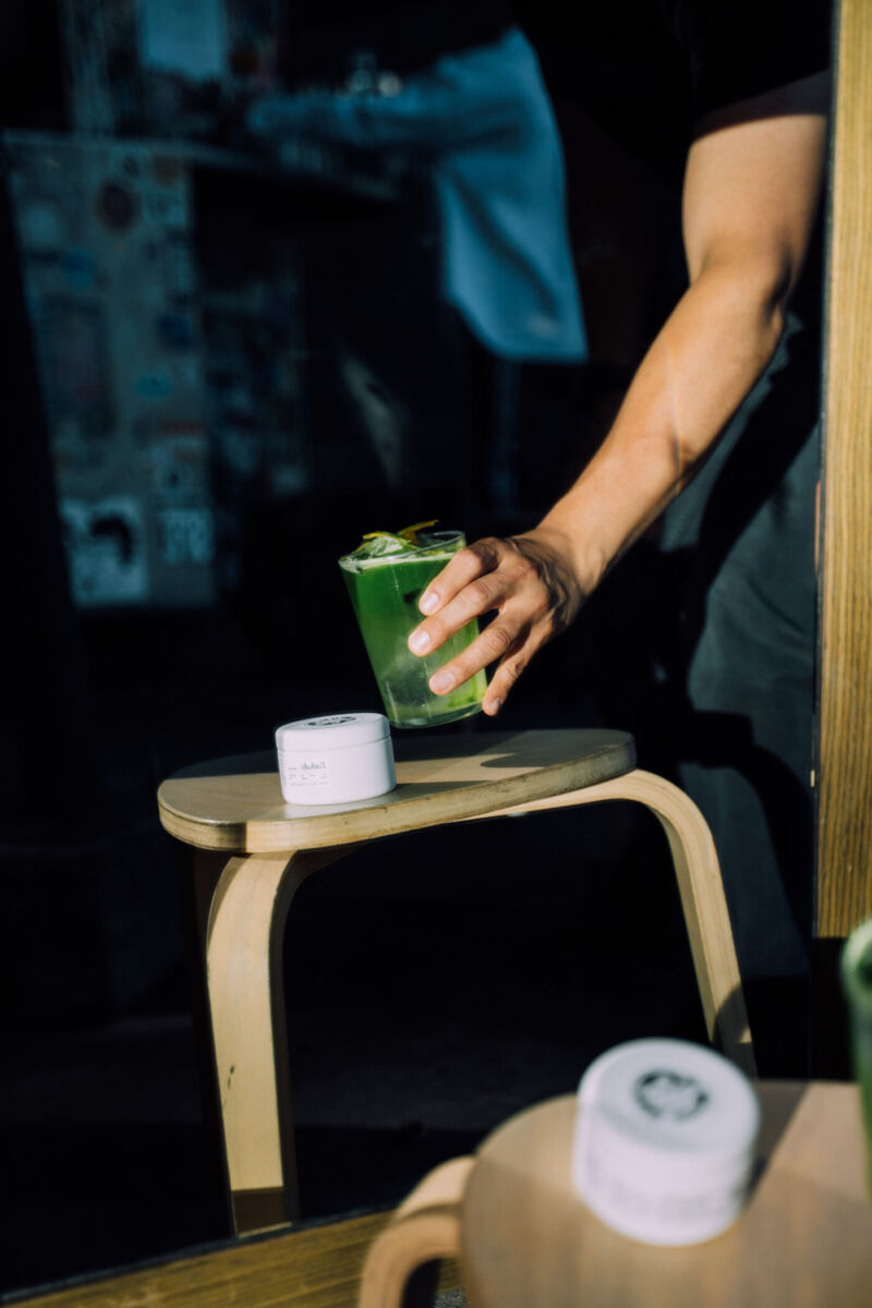 hombre poniendo una bebida de matcha sobre un banco 