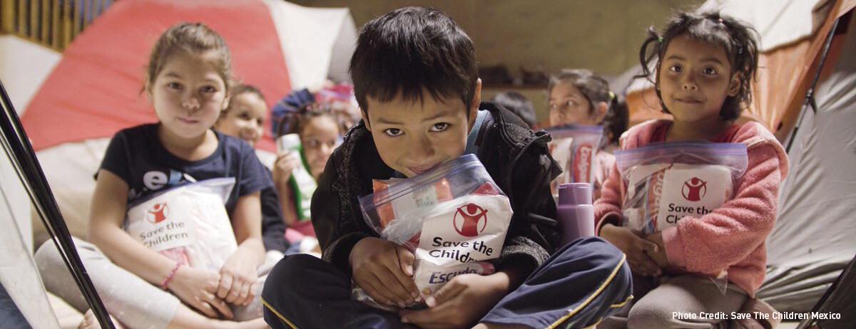 niños mexicanos abrazando paquetes de save the children