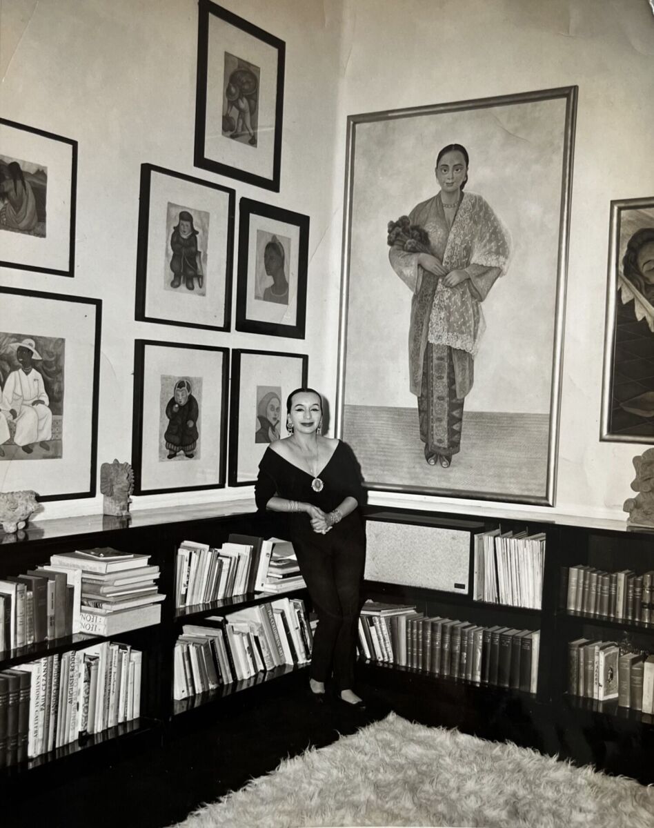 fotografía en blanco y negro de dolores olmedo posando con sus cuadros y sus libros