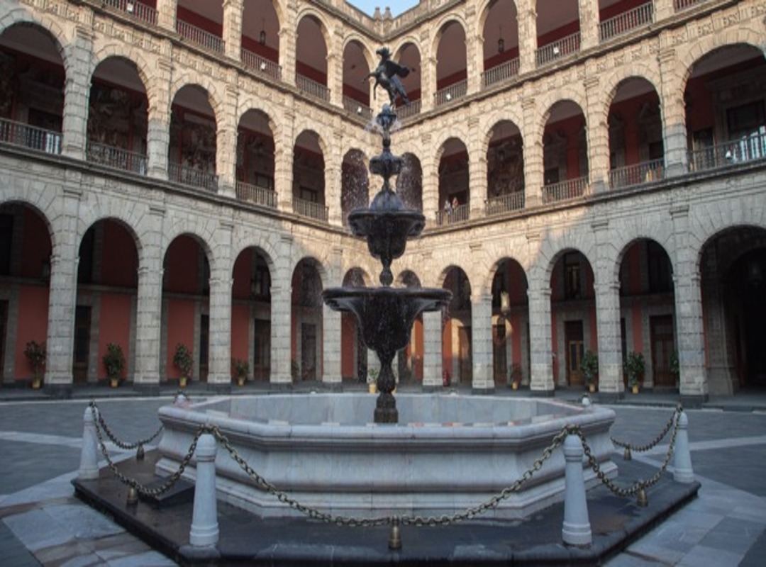 edificio con muchos arcos y una fuente en medio